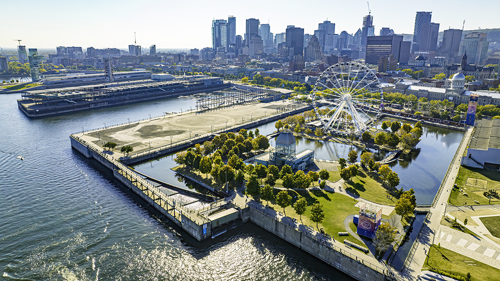 Aerial view of Montreal's Old Port, with the Ferris wheel in the foreground and the city skyline in the background.
