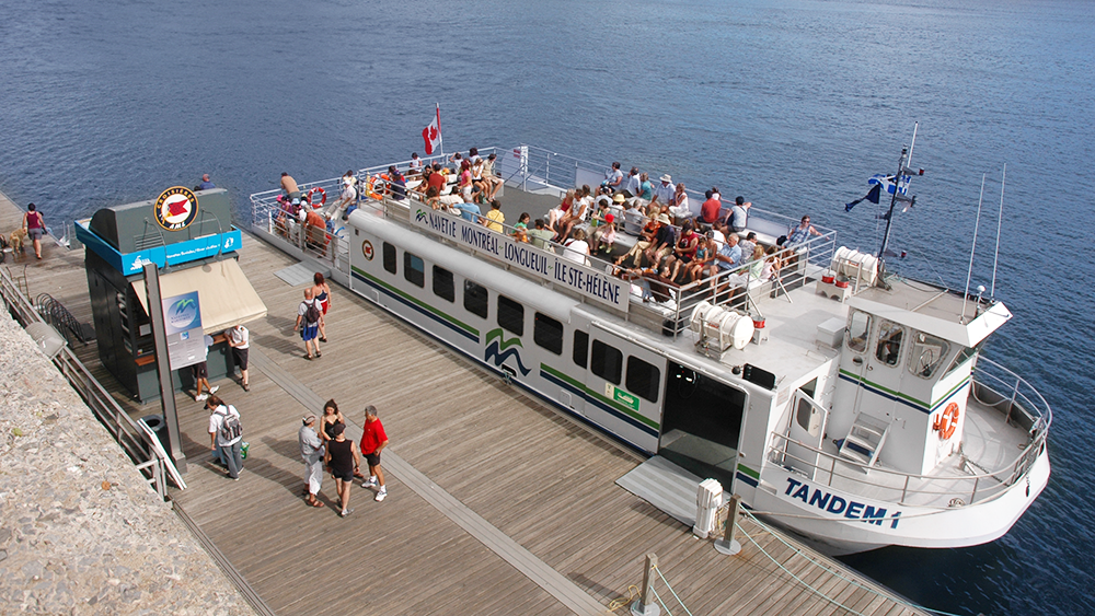 La navette fluviale à quai accueillant des passagers à son bord. 