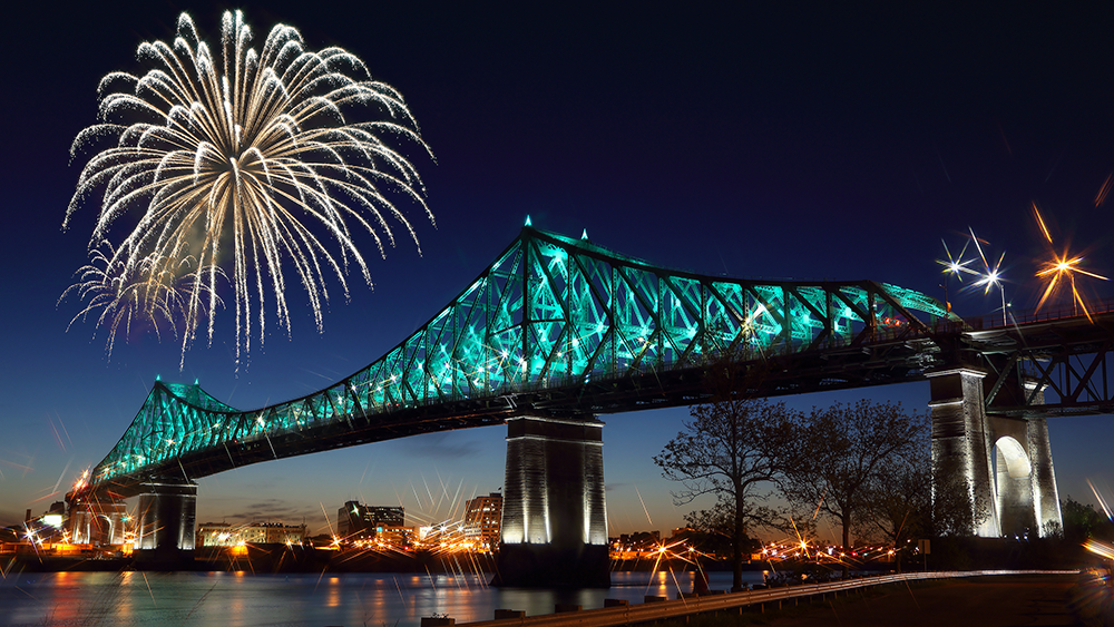 Pont Jacques Cartier à Montréal de nuit et éclairé avec des feux d'artifice surplombant le monument 