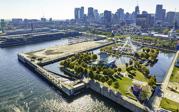 Aerial view of Montreal's Old Port, with the Ferris wheel in the foreground and the city skyline in the background.