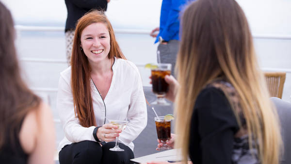  Friends talking on the terrace with a drink in their hands