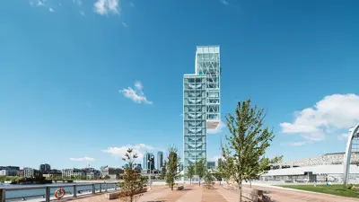 Tour du Port de Montréal avec en premier plan une esplanade arborée et en arrière plan des immeubles de Montréal