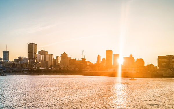 Un coucher de soleil projetant une lueur chaleureuse sur la skyline de Montréal.