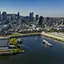 Vue aérienne du navire AML Cavalier Maxim sortant du Vieux Port de Montréal avec une vue sur la ville en arrière plan sous un ciel bleu