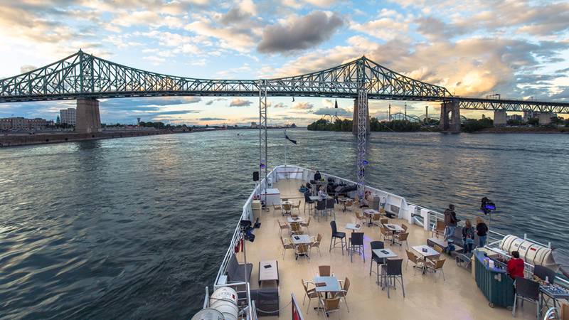 View from the front outdoor terrace of the AML Cavalier Maxim ship, with a panoramic background of the Saint Lawrence River and the city of Montreal