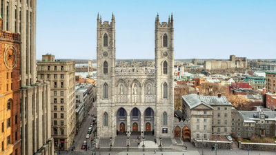 Basilique Notre-Dame de Montréal avec en premier plan la place d'Armes et quelques immeubles de Montréal