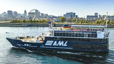 Le navire AML Cavalier Maxim naviguant sur le fleuve Saint-Laurent avec le Vieux-Port et la skyline de Montréal en arrière plan.