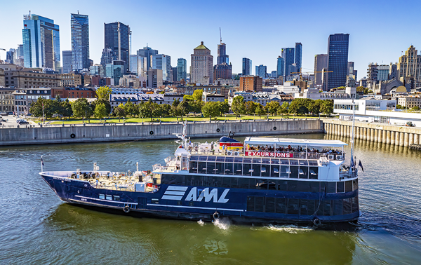 Aerial view of the AML Cavalier Maxim parked in Montreal's Old Port by day, with a view of the city skyline in the background.