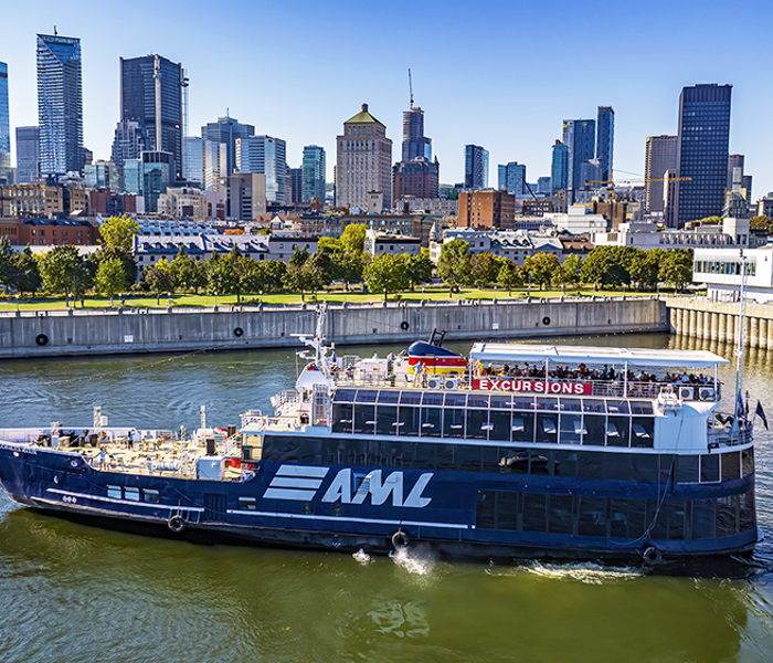 Aerial view of the AML Cavalier Maxim parked in Montreal's Old Port by day, with a view of the city skyline in the background.